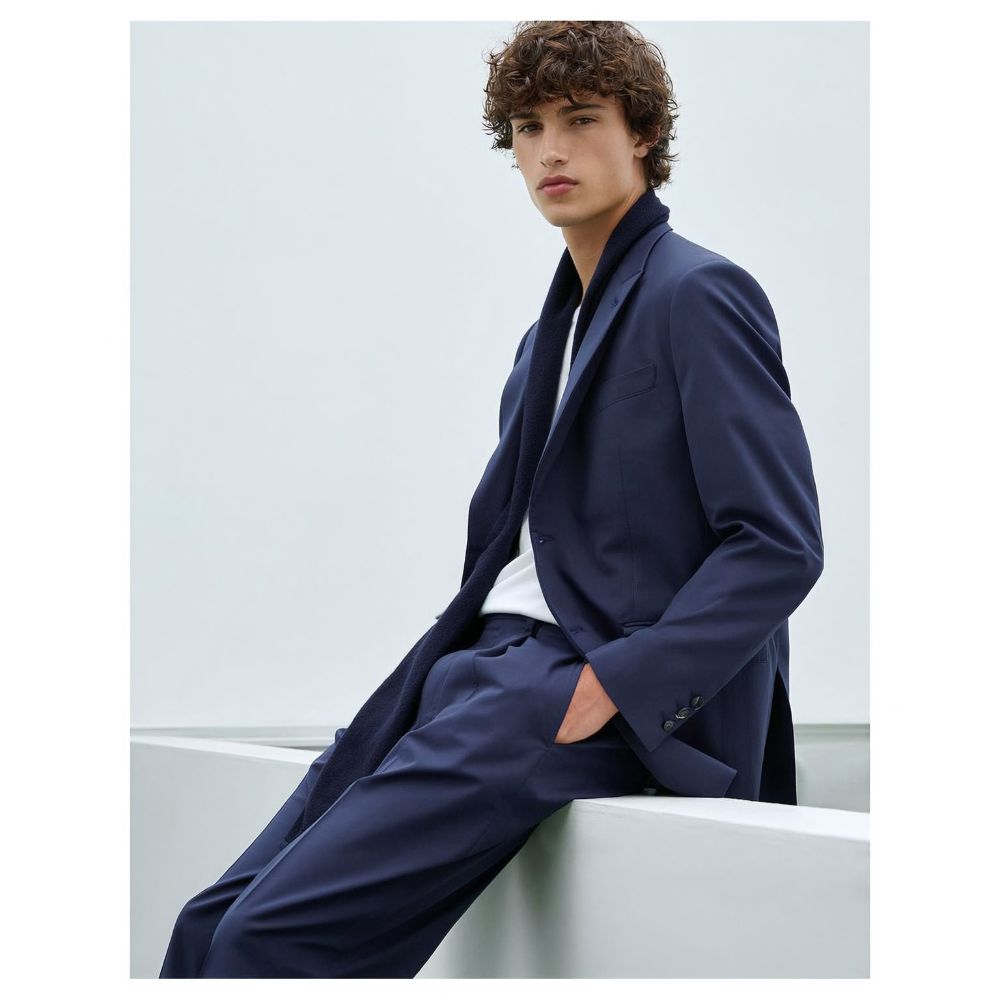 Model amb vestit navy sobre fons clar